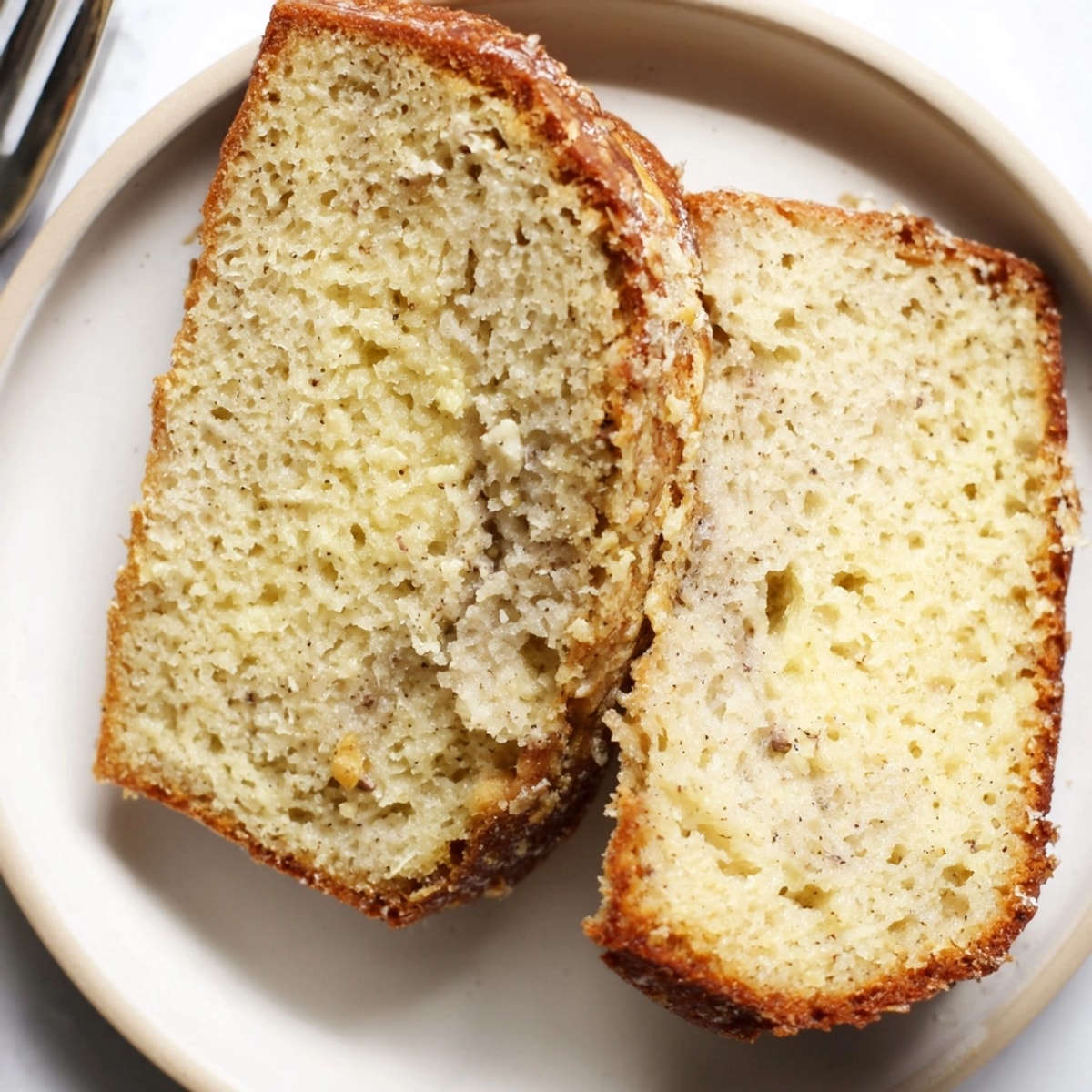 Slices of moist Ricotta Vanilla Bean Bread ready for serving alongside berries.