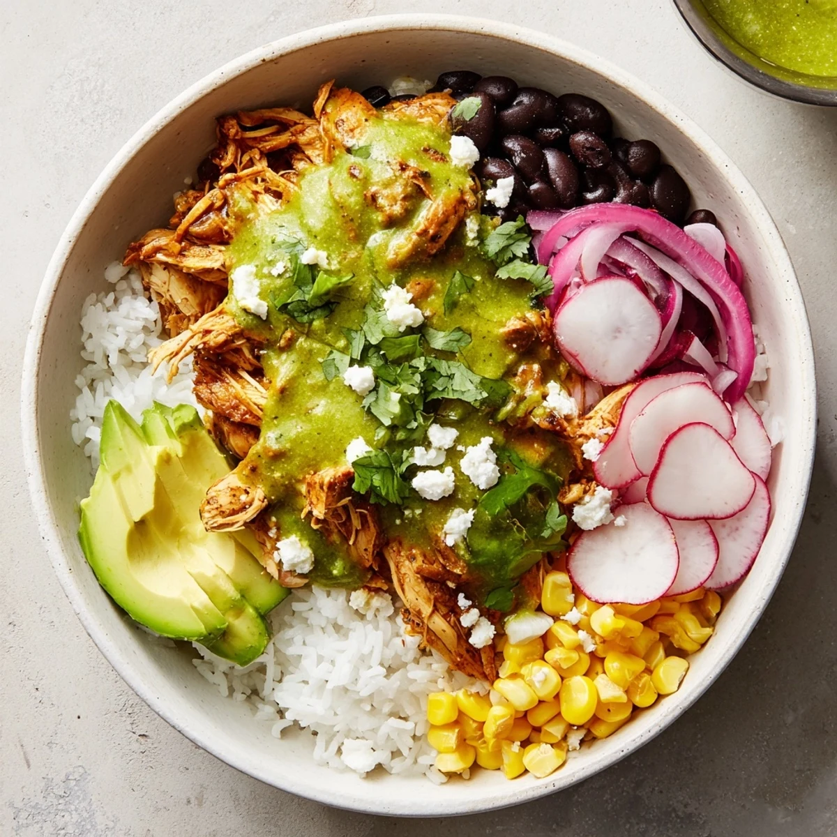 This Green Enchiladas Rice Bowl features tender chicken and fluffy rice smothered in zesty sauce, ready to enjoy.