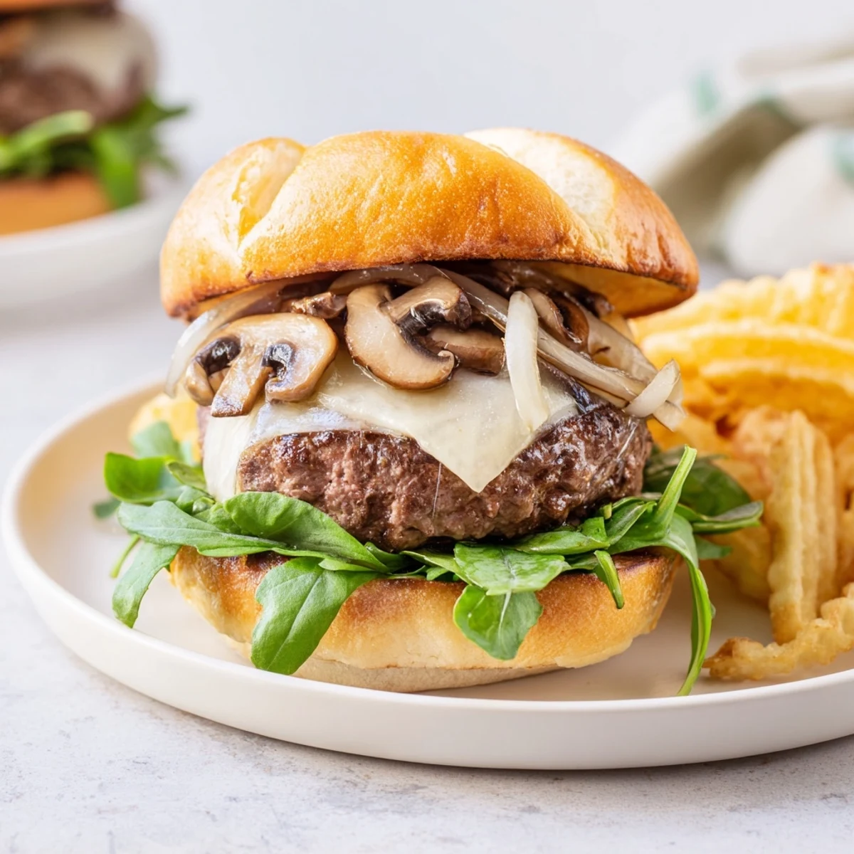 Golden-brown waffle fries accompany a flavorful Mushroom Swiss Burger bursting with sauteed mushrooms.