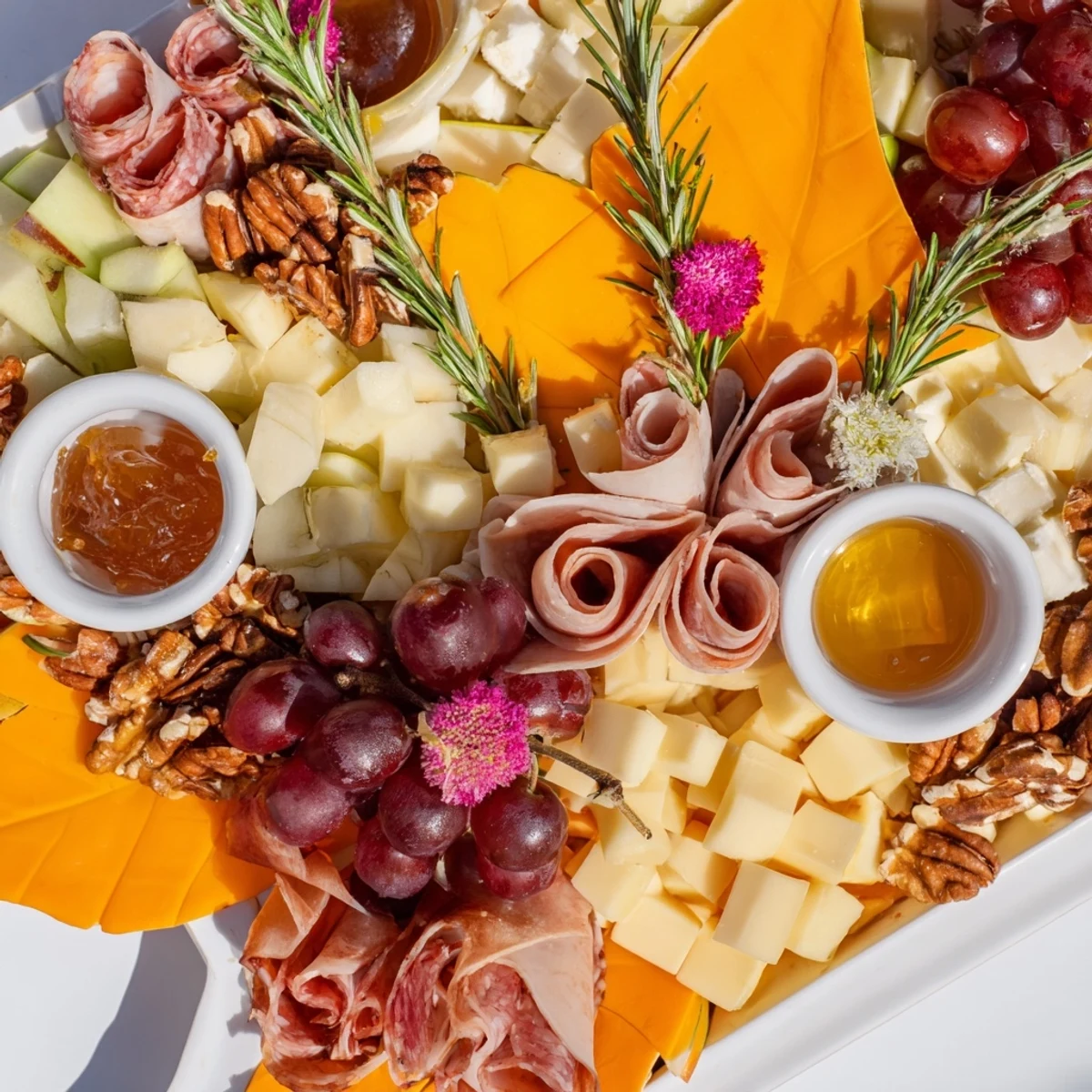 A beautiful Maple Leaf Grazing Tray: an autumn appetizer with cheeses, fruits, and meats.