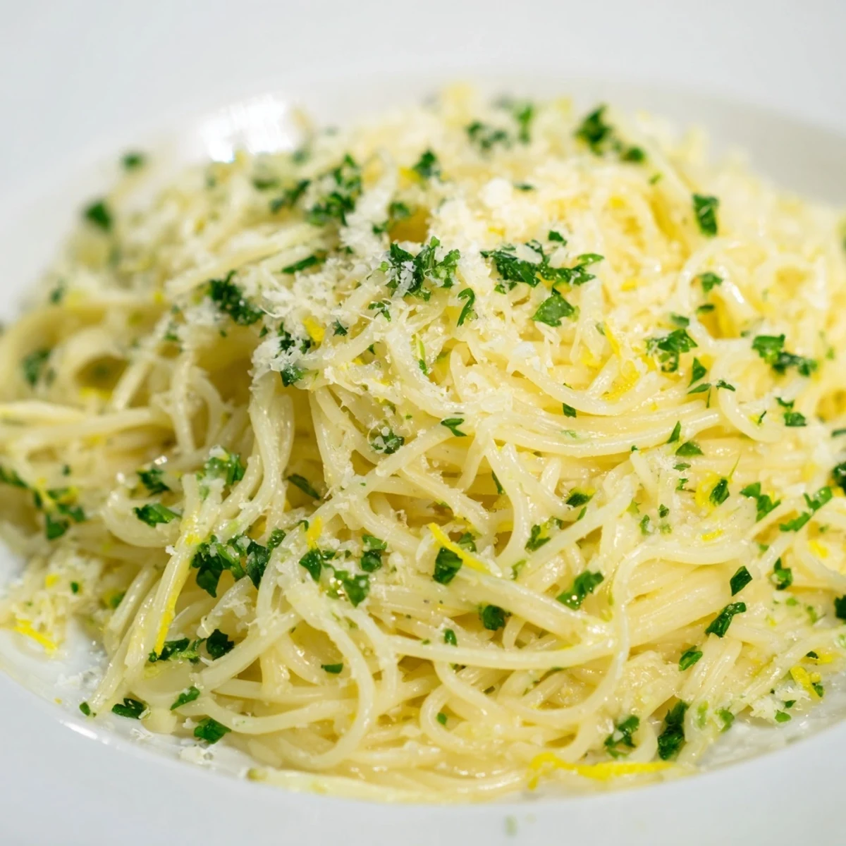 Steaming bowl of Lemon Capellini, the thin pasta coated in a creamy, lemony sauce with basil.