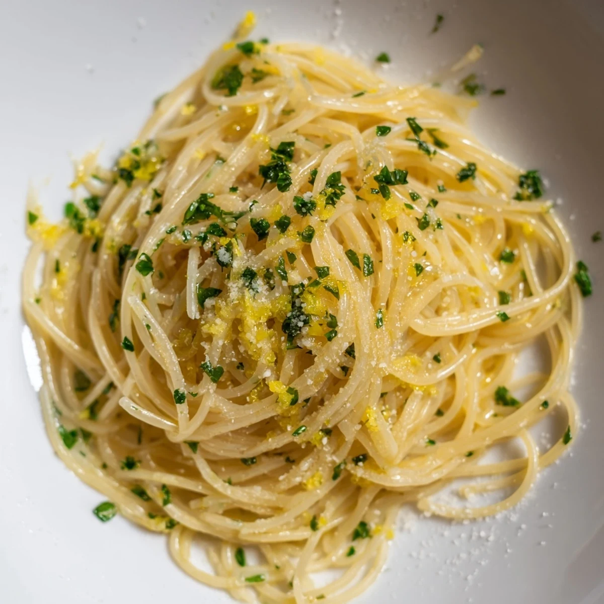Delicate Lemon Capellini pasta tossed in a bright lemon butter sauce with vibrant fresh herbs.