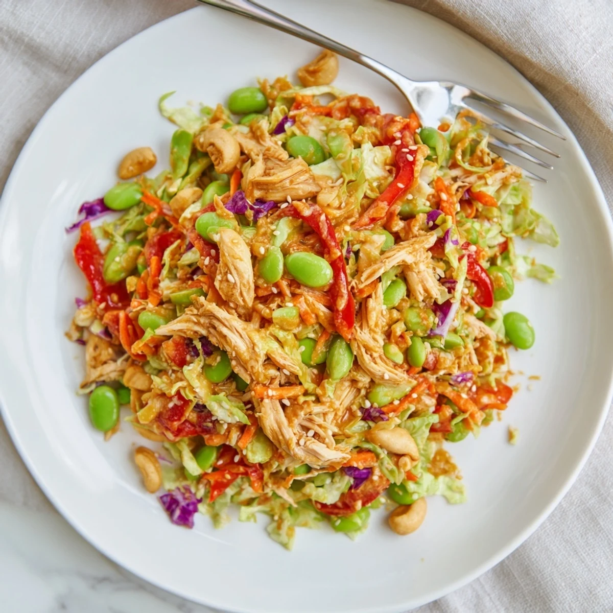 Healthy Edamame Crunch Chicken Salad served chilled with red bell pepper strips and edamame, perfect for a light lunch.