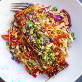 A beautifully plated Teriyaki Salmon & Asian Slaw Bowl with sesame seeds and fresh spring onions.