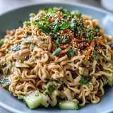 Creamy sesame peanut dressing coats cold noodles, topped with fresh cucumber, carrots, and herbs.  