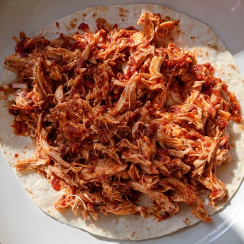 Tender Crock-Pot Shredded Chicken Tacos spilling out of a warm tortilla, ready to enjoy with fresh toppings.