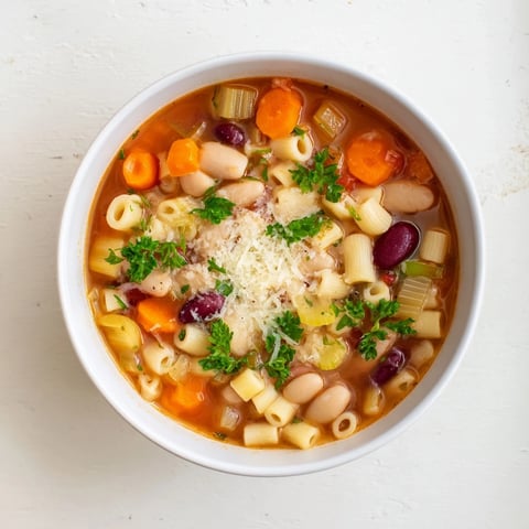Steaming hot Pasta e Fagioli soup, a hearty bowl with visible pasta and creamy beans.
