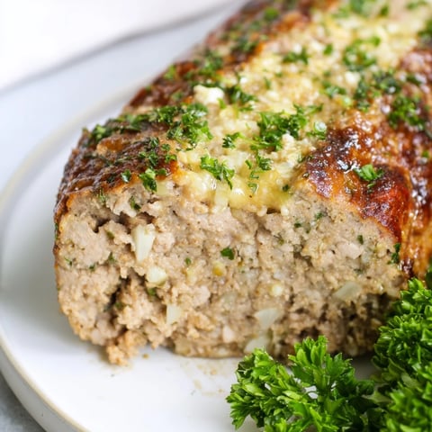 Golden and bubbly, the juicy Garlic Parmesan Chicken Meatloaf is ready to serve for dinner.