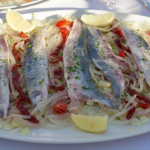 Plongeons dans lOcéan Poisson Bleu: baked bluefish glistening with tomatoes and herbs, a colorful and delicious seafood dish.