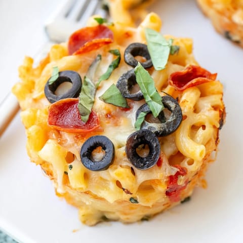 Handheld, savory Mac and Cheese Alfredo Pizza Muffins ready for a fun family dinner.