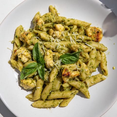 Golden chicken and al dente penne pasta coated in creamy pesto – ready for delicious eating.