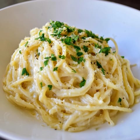 Freshly plated Creamy Three-Cheese Spaghetti with a sprinkle of parsley; smells delicious and cheesy.