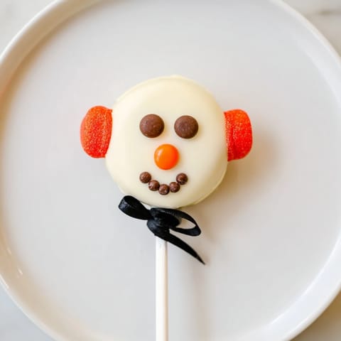 These adorable Budget-Friendly Oreo Snowman Pops are decorated with chocolate chips, perfect for a fun treat.
