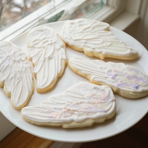 Freshly baked Angel Wings Sugar Cookies showing intricate wing details, perfect for any holiday dessert buffet.