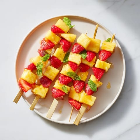 Sweet strawberry halves and pineapple chunks arranged on skewers, ready to be enjoyed.