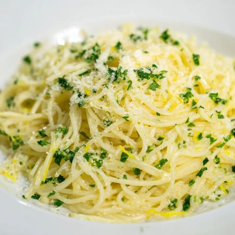 Steaming bowl of Lemon Capellini, the thin pasta coated in a creamy, lemony sauce with basil.