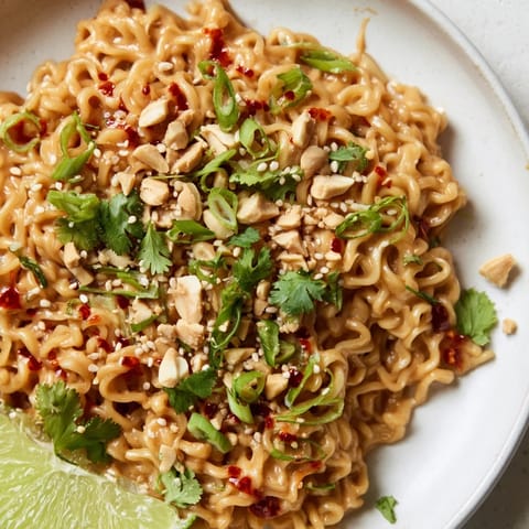 Close-up of vibrant Instant Peanut Thai Sauce Noodles, showcasing a creamy peanut butter glaze on cooked noodles.