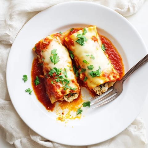 Close-up view of Chicken and Spinach Lasagna Rolls, showing tender pasta spirals stuffed with vibrant spinach, chicken, and melted cheese.  
