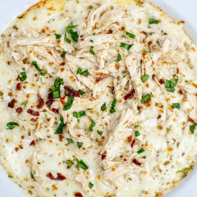 A close-up of lightened Marry Me Chicken Dip, showcasing sun-dried tomatoes and herbs; ready to be served.