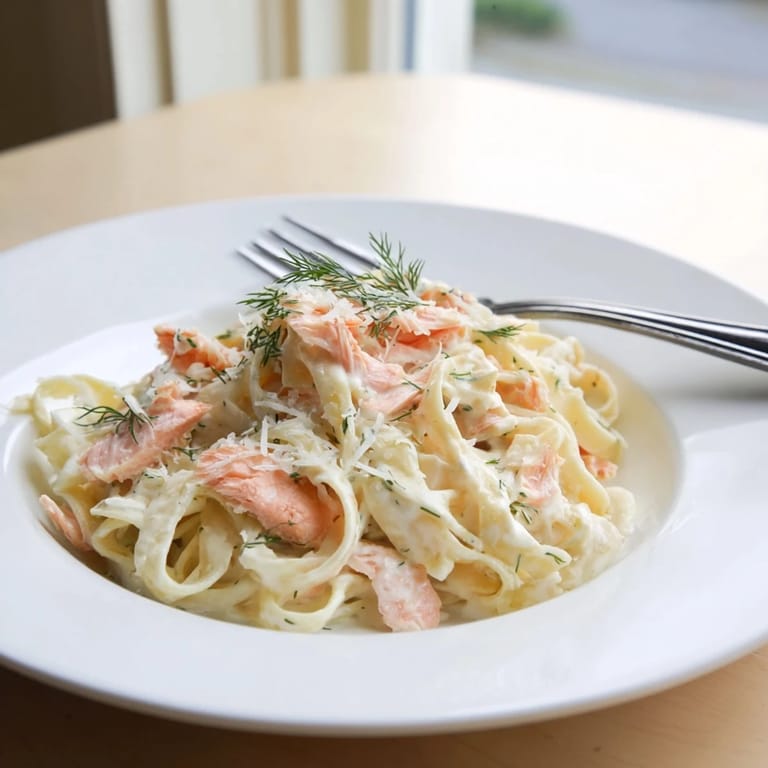 Creamy salmon pasta twirled on a fork, drizzled with lemon and Parmesan, ready for an easy, elegant weeknight meal.