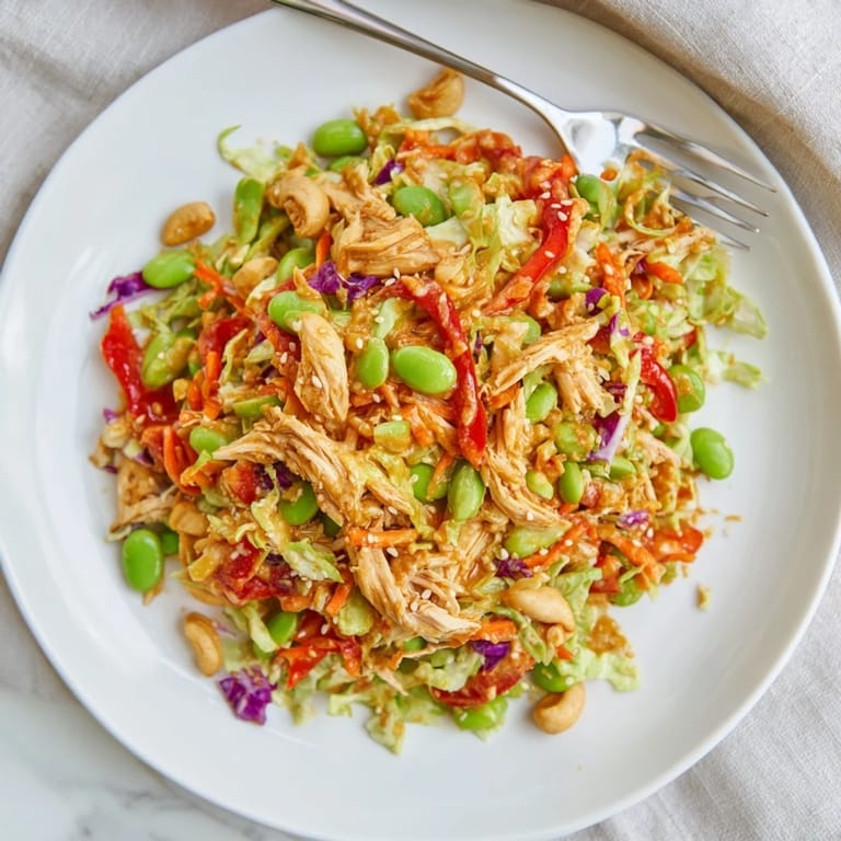 Healthy Edamame Crunch Chicken Salad served chilled with red bell pepper strips and edamame, perfect for a light lunch.