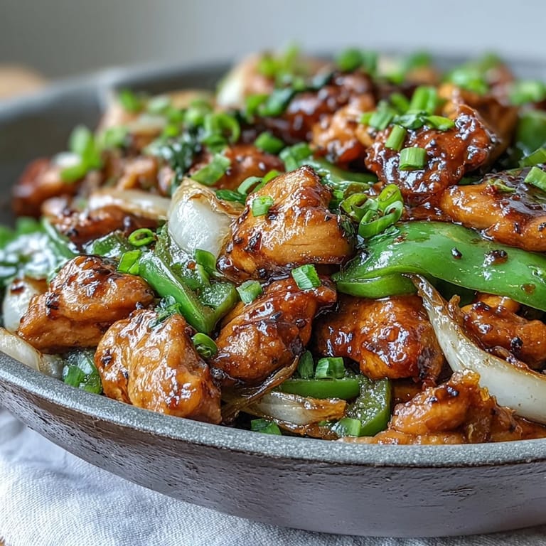 Sizzling Black Pepper Chicken in a wok with onions and peppers, showcasing the bold stir-fry flavors of this Asian-inspired dish.