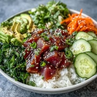 Colorful canned tuna poke bowl with avocado and cucumber, ready to eat.