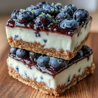 No-bake lemon blueberry cheesecake bars with creamy swirls on buttery crust.
